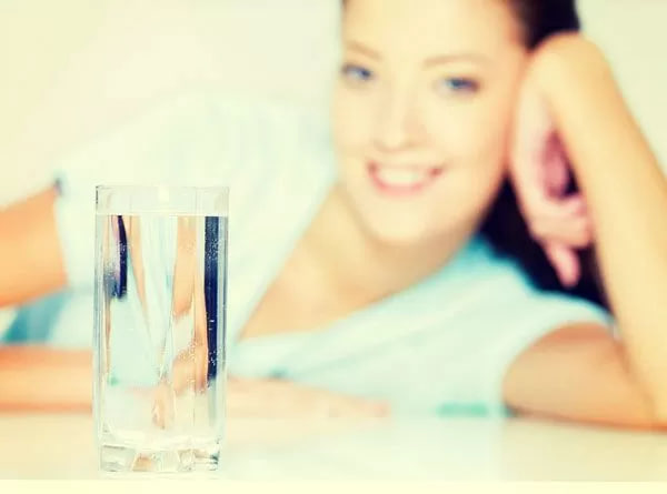 стакан с водой на фоне девушки